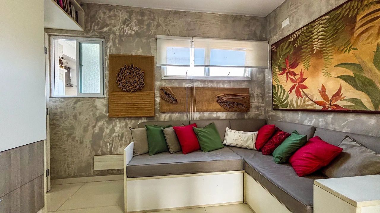Una sala de estar moderna con un sofá modular, decoración de pared y una ventana que deja entrar luz natural.