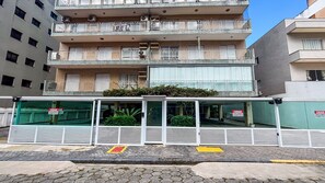 A multi-story building with balconies, a gated entrance, and a sign indicating a closed status. - SHB Cobertura e Piscina Privativa  (GUARUJÁ)