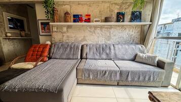 A modern living room with a grey sofa, a red chair, and a small table.