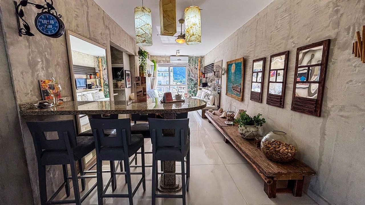 Una cocina con una isla central, taburetes de bar y un banco largo.