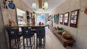 A kitchen with a central island, bar stools, and a long bench.