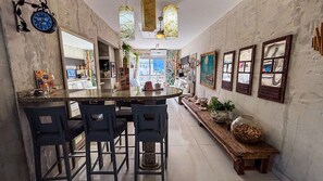 A kitchen with a central island, bar stools, and a long bench. - SHB Cobertura e Piscina Privativa  (GUARUJÁ)