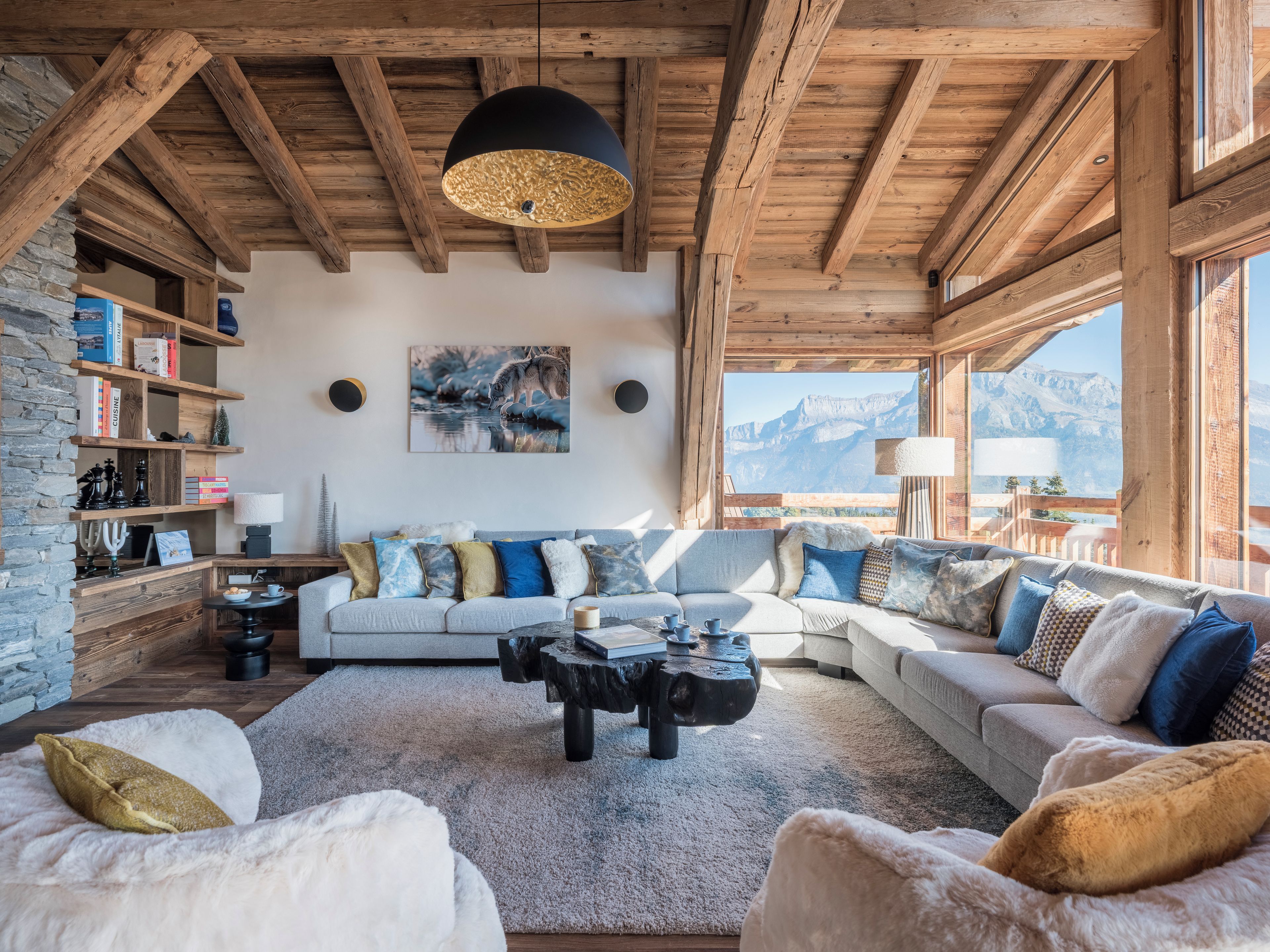 Una sala de estar acogedora con chimenea, un conjunto de sofás, una mesa de centro y una estantería.
