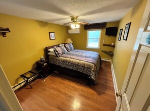A bedroom with a bed, a ceiling fan, a window, and a door. - Bowman inn Spacious 12-bedroom estate in beautiful Randolph with AC/pool/hottub (Randolph)