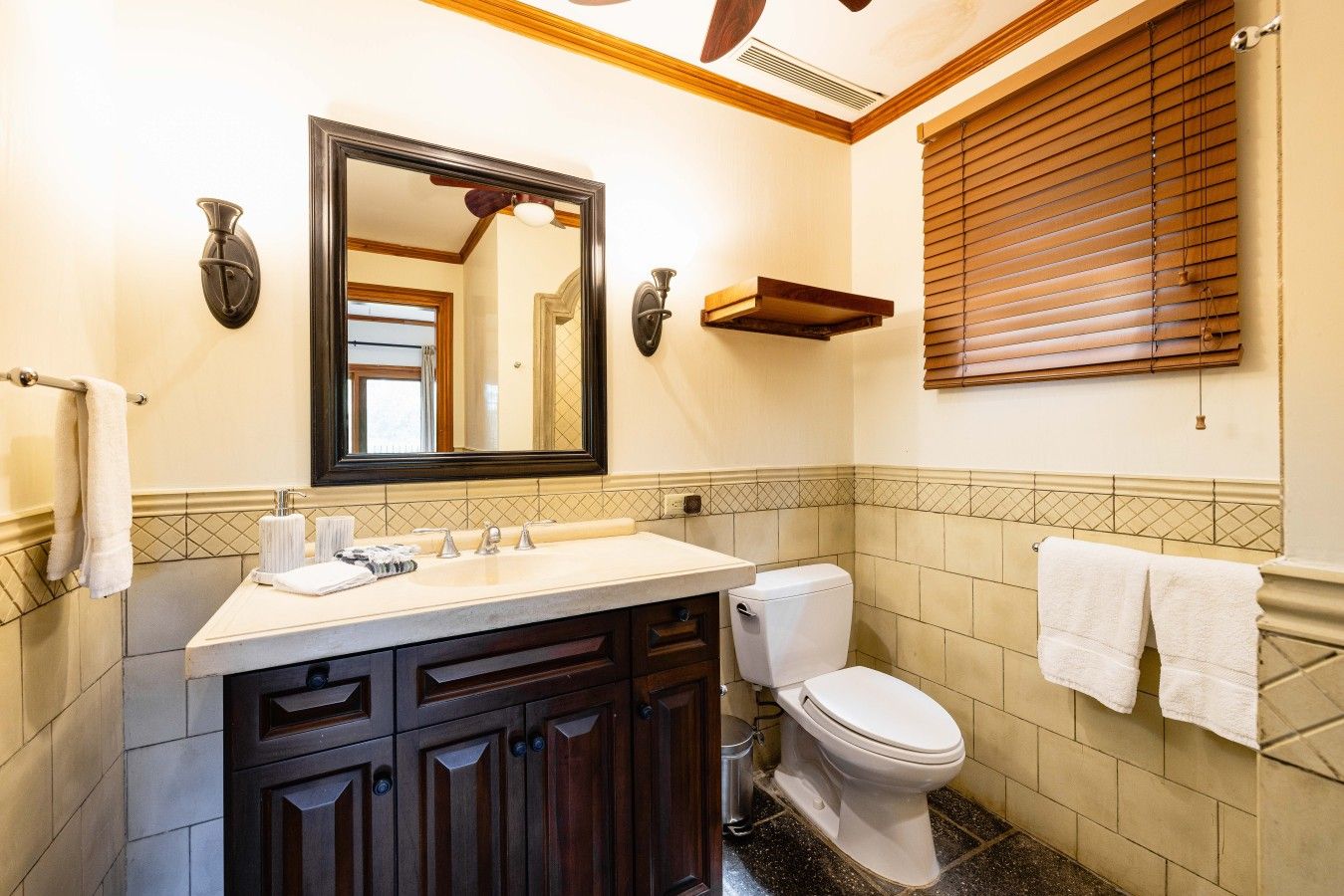 Een badkamer met een wastafel, spiegel, toilet en handdoekrek.
