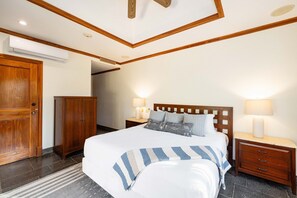 Ein Schlafzimmer mit einem Bett, Nachttischen, einem Kleiderschrank und einer Klimaanlage.