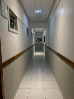 A long, narrow hallway with white walls and a wooden baseboard. - 105 · 105 AP 2 Bedrooms Practical and Functional (Belém)