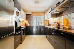 A modern kitchen with stainless steel appliances, black cabinets, and a central island. - A vacation home where you feel right at home... (Las chafiras)