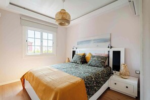 A bedroom with a bed, bedside tables, a window, and a hanging light fixture. - A vacation home where you can feel right at home... (Las chafiras)