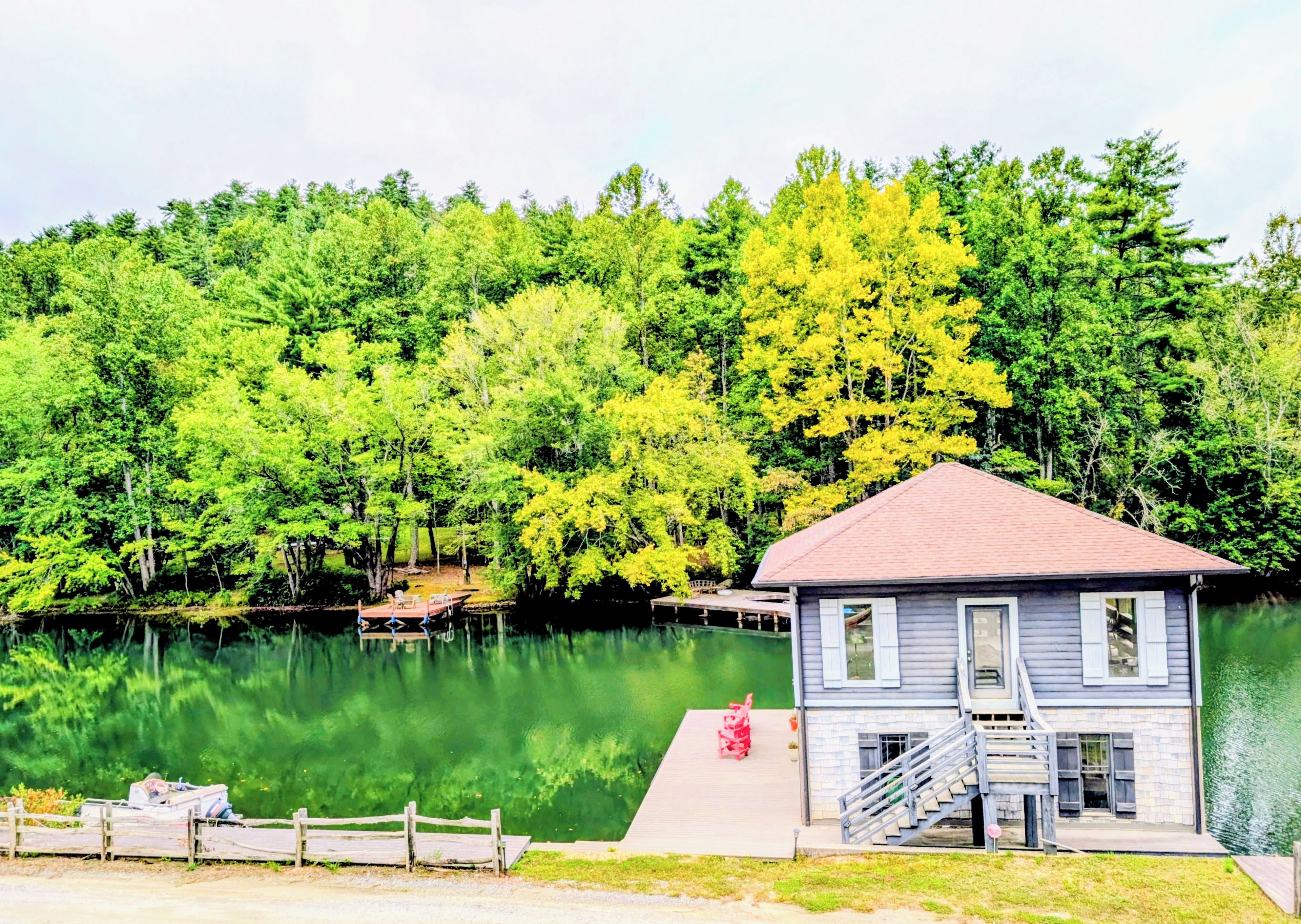 A lakeside cabin with a dock, surrounded by dense forest.