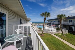 A hotel with a pool area, outdoor seating, and a view of the beach. - Pet Friendly Townhome Directly Across from the Beach in Quiet Ormond By the Sea (Ormond Beach)