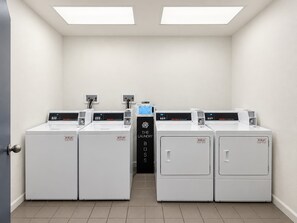 Eine Waschküche mit vier Waschmaschinen und einer zentralen Steuerungseinheit.