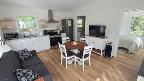 A compact living space with a kitchenette, dining area, and a sofa.