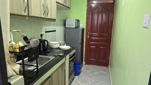 A compact kitchen with a microwave, refrigerator, and various cooking utensils. - Kamakis,Ruiru Eastern bypass (Ruiru)