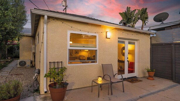 A residential building with a patio, a chair, a potted plant, and a satellite dish. - Private, designer furnished, freestanding 1 bedroom ADU in Los Angeles (Los Angeles)