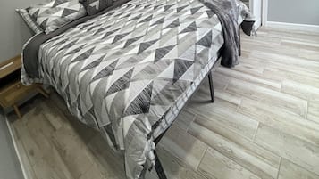 Makuuhuone, jossa on sänky, vaatekaappi ja peili.