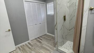 A bathroom with a shower, toilet, and a vanity.