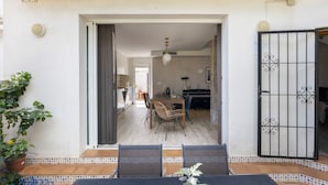 An open doorway leading to a dining area with a table and chairs, a piano, and a view into a kitchen.