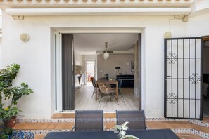 An open doorway leading to a dining area with a table and chairs, a piano, and a view into a kitchen.