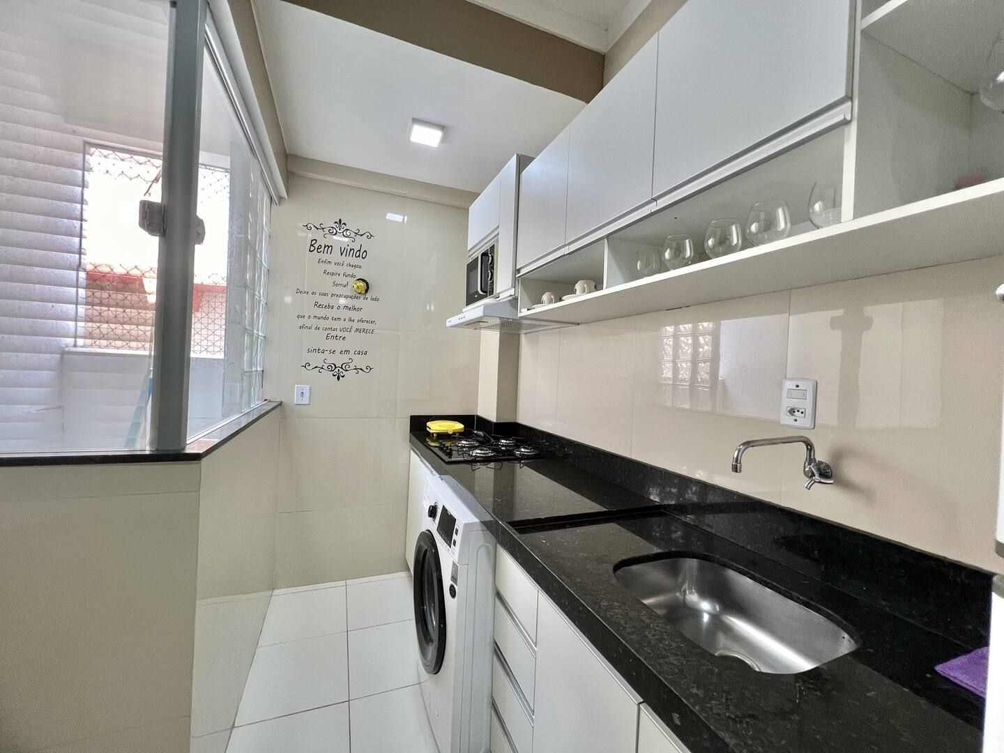 Cocina compacta con lavadora, lavaplatos y microondas.