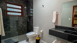 A bathroom with a toilet, a sink, a mirror, and a window. - Casa Ponte Floripa (Florianópolis)