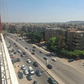 A busy urban street with multiple lanes of traffic, buildings with satellite dishes, and parked cars. -  Luxurious 270m Apartment in Nasr City (Cairo Governorate)