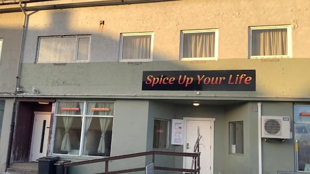 A building with a sign that reads 'Spice Up Your Life' and a staircase leading to the entrance.