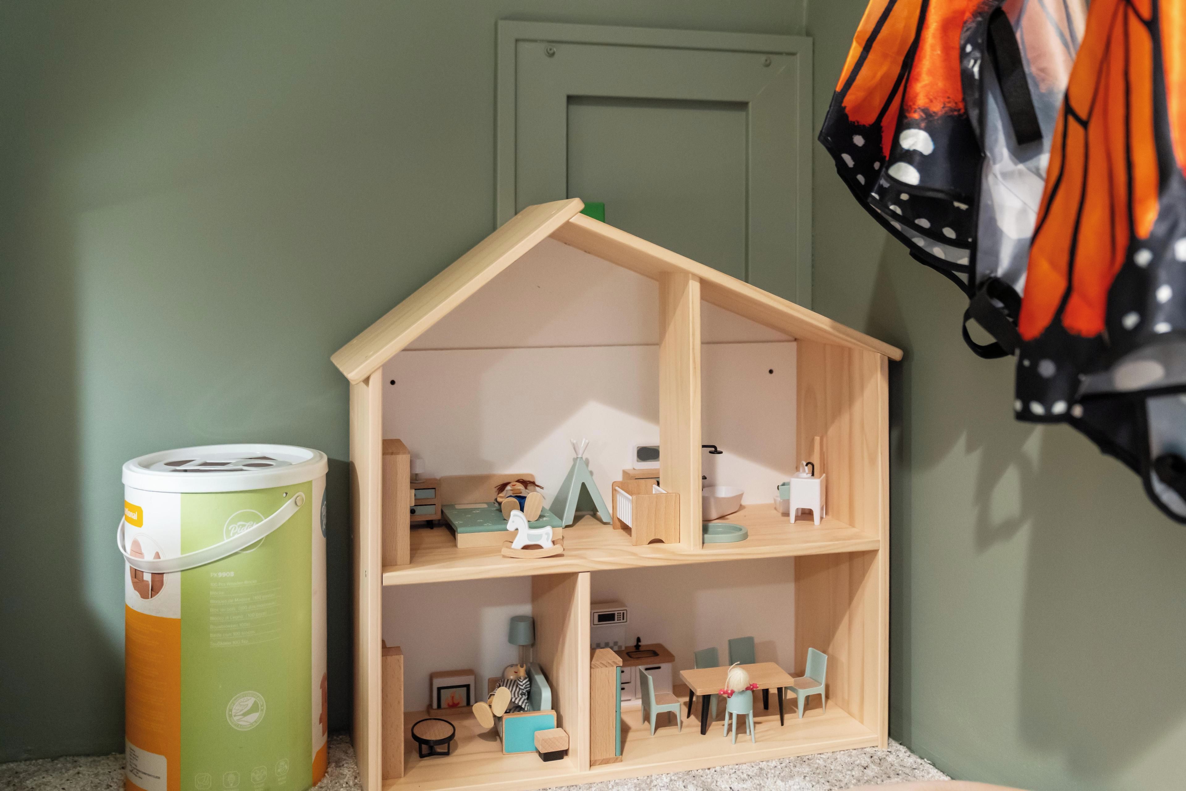 Una casa de muñecas con cocina, comedor y un dormitorio pequeño.