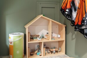 Una casa de muñecas con cocina, comedor y un dormitorio pequeño.