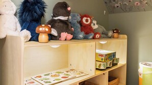 A shelf with plush toys and a children's educational book.