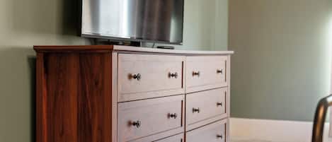 Un aparador de madera con cajones y un televisor encima.