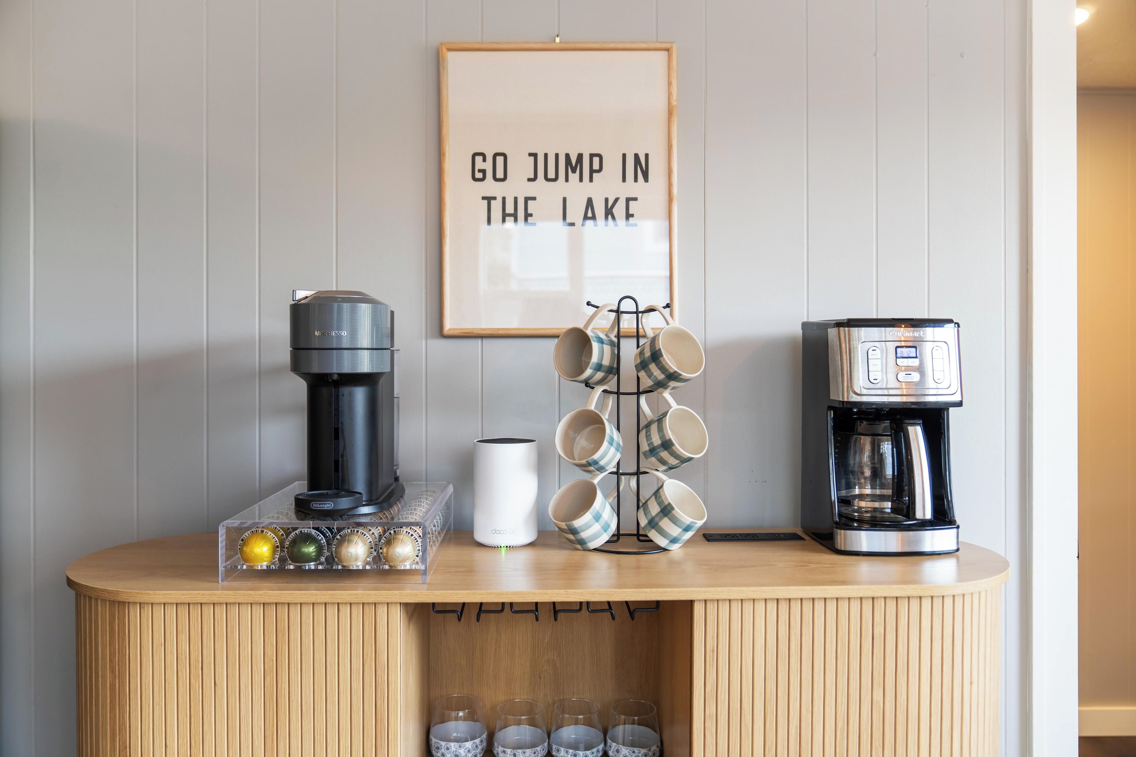 A coffee station with a coffee maker, a milk frother, and a mug rack.