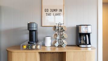 A coffee station with a coffee maker, a milk frother, and a mug rack.