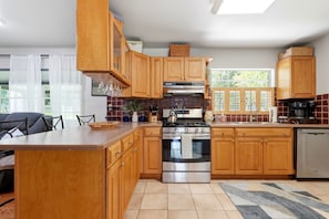 Una cocina moderna con armarios de madera, una isla central y un ventanal que proporciona luz natural.
