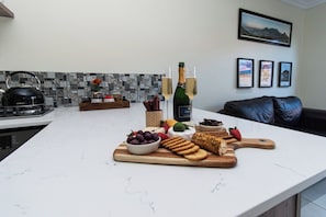 A kitchen counter with a variety of food items and a bottle of champagne. - Comfortable Living within walking distance to go swim, surf, dine or just relax (Cape Town)