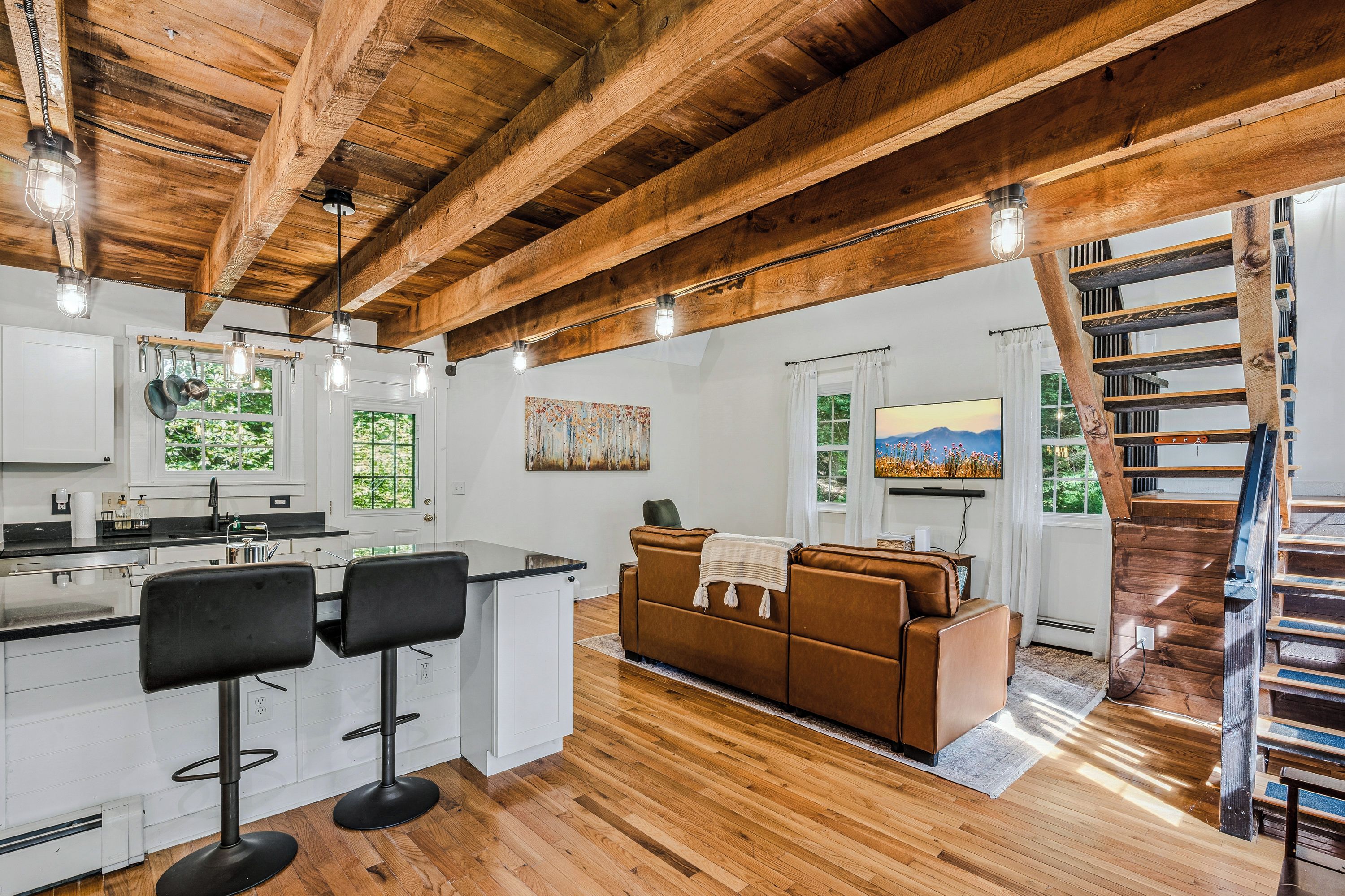 A spacious living area with a wooden ceiling, a sofa, a coffee table, and a television.