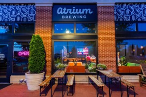 Atrium-Brauerei mit Schaufenster, Außenbereich und einer Neonreklame.