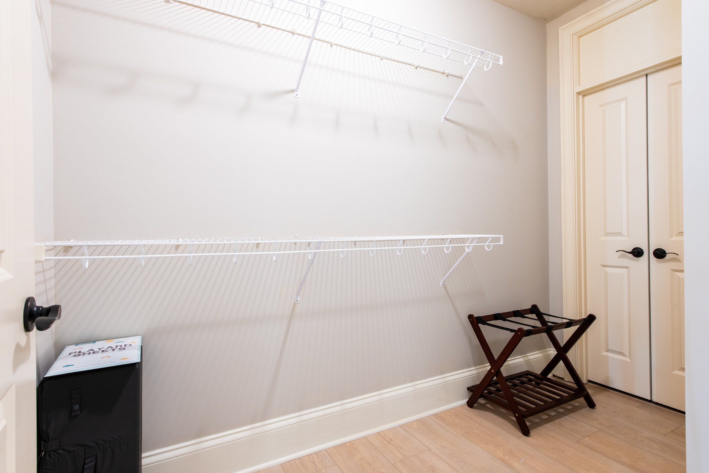 Une pièce avec une porte blanche, un mur blanc et un plancher en bois.