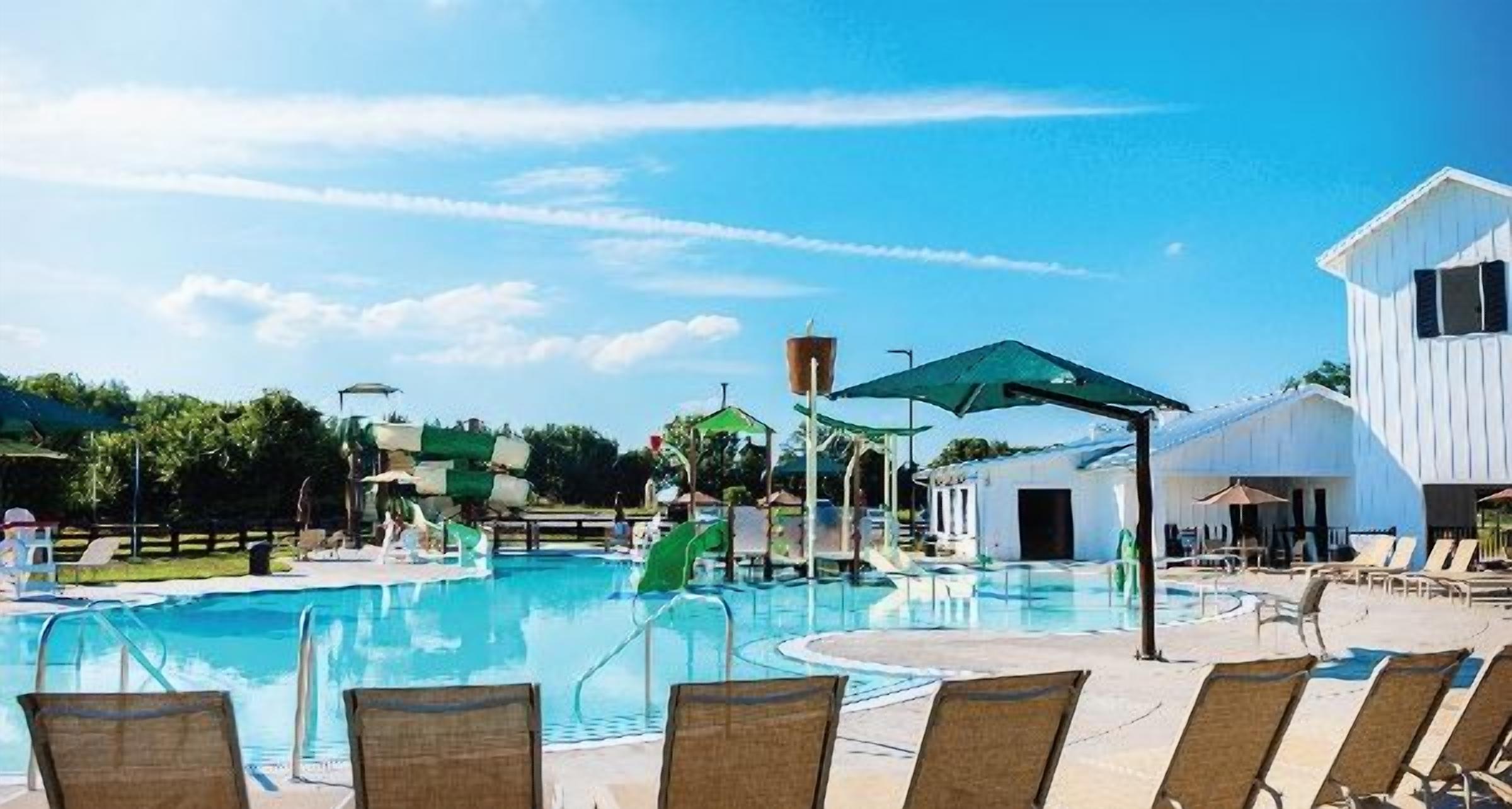 Une piscine équipée de chaises longues et d’un toboggan aquatique.