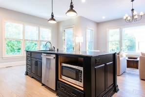 A kitchen with a central island, built-in microwave, and double sink.
