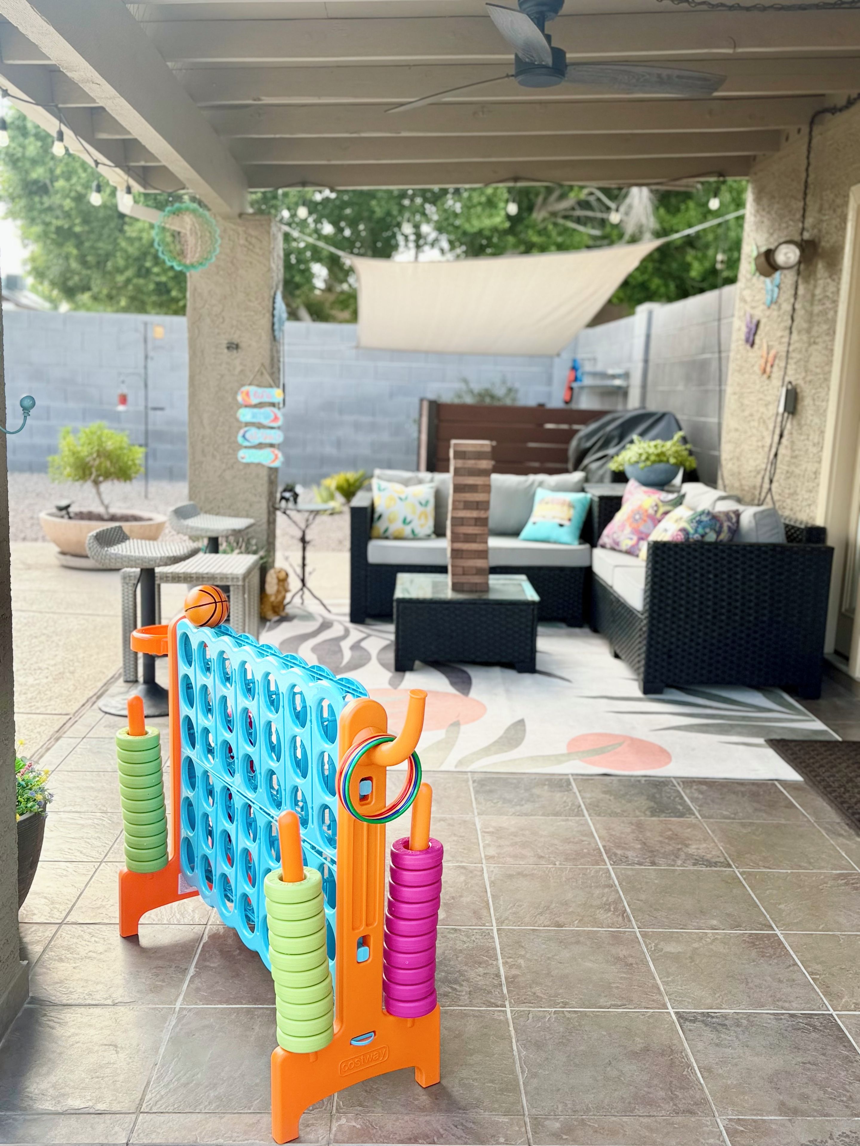 An outdoor seating area with a covered patio, a table with chairs, and a decorative play structure.