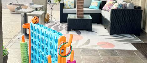 An outdoor seating area with a covered patio, a table with chairs, and a decorative play structure.