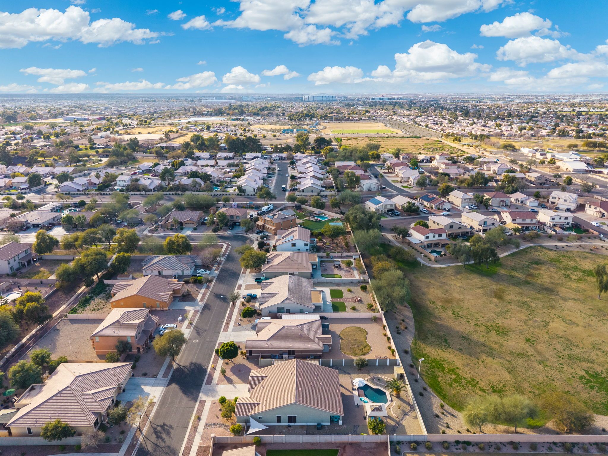 Un quartier résidentiel avec des maisons, des rues et un grand espace vert.