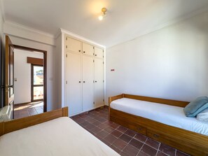 A bedroom with a bed, a wardrobe, and a door leading to an outdoor area. - Alto da Villa by Acasadascasas (Mafra)