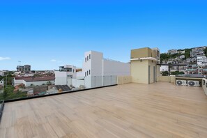 Terrassa al terrat amb una vista clara del paisatge urbà, amb edificis moderns i una collada allunyada.