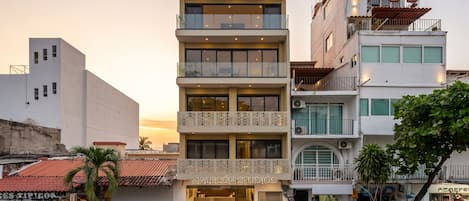 Un edificio de varios pisos con locales comerciales en la planta baja y unidades residenciales u oficinas en los pisos superiores.