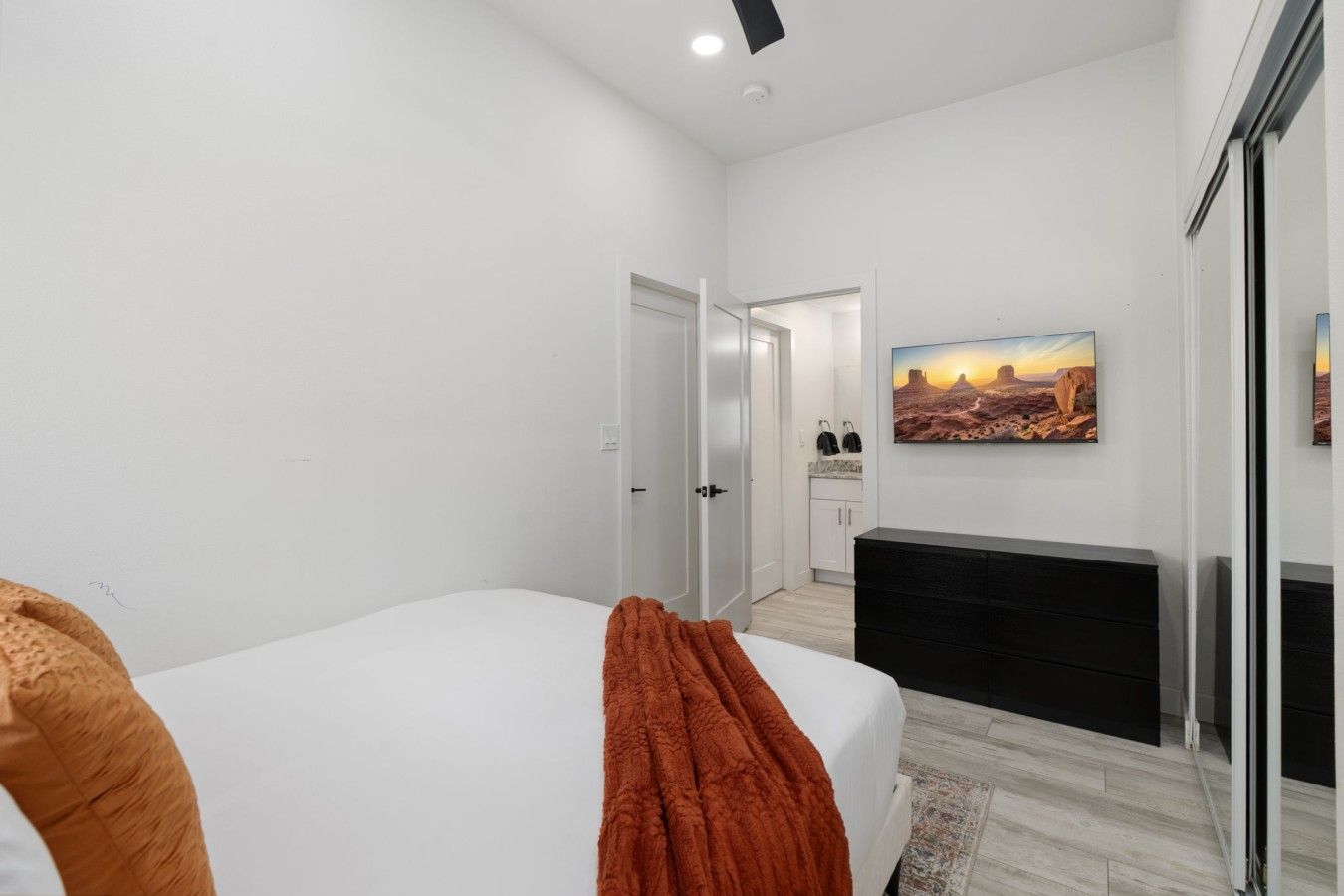 Une chambre à coucher avec un lit, une cheminée, un tableau et une porte donnant sur une salle de bain.