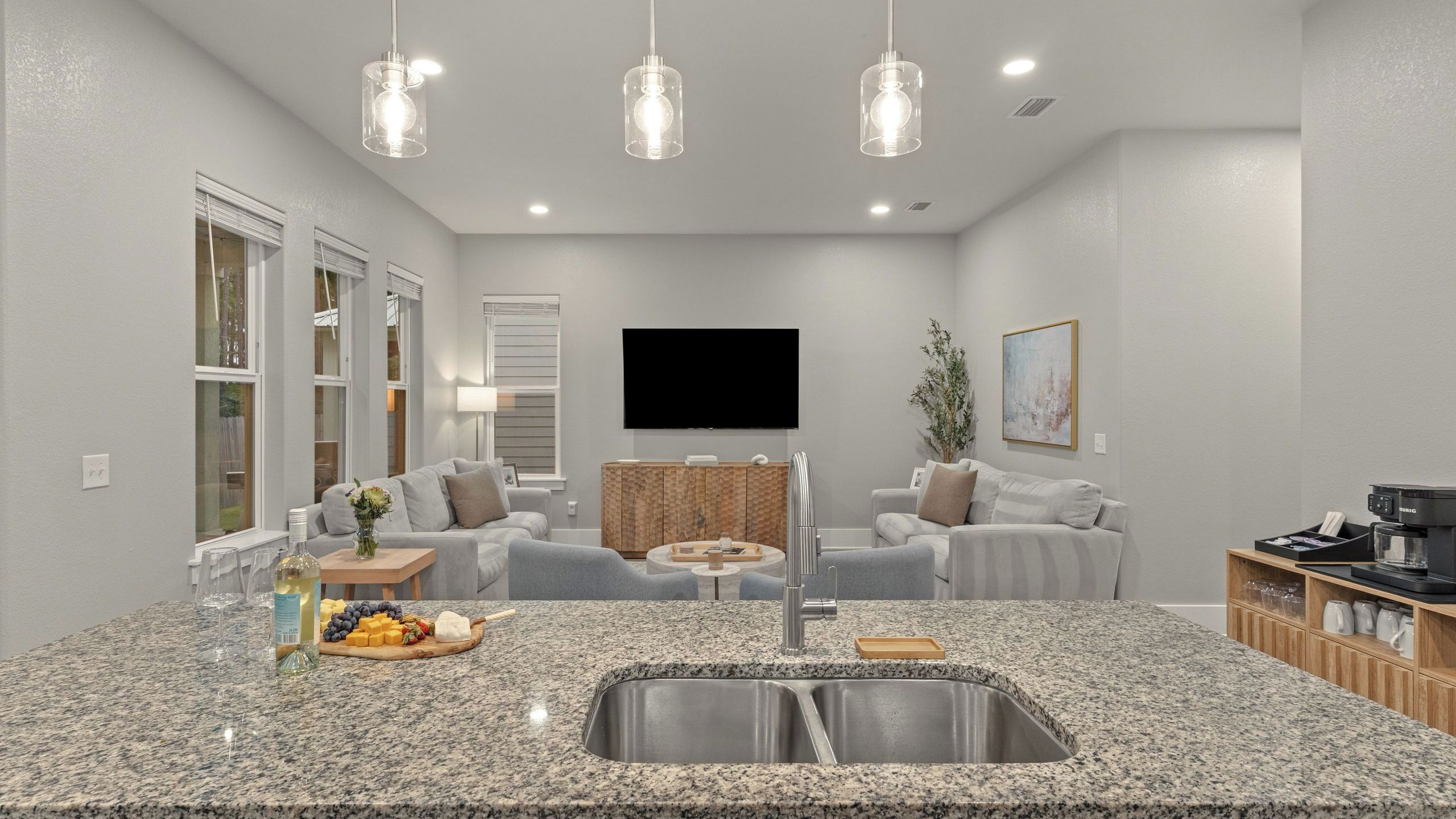 A modern kitchen with granite countertops, a stainless steel sink, and a built-in oven.