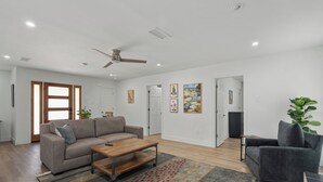 Un salon moderne avec un canapé, une table basse et un ventilateur de plafond.