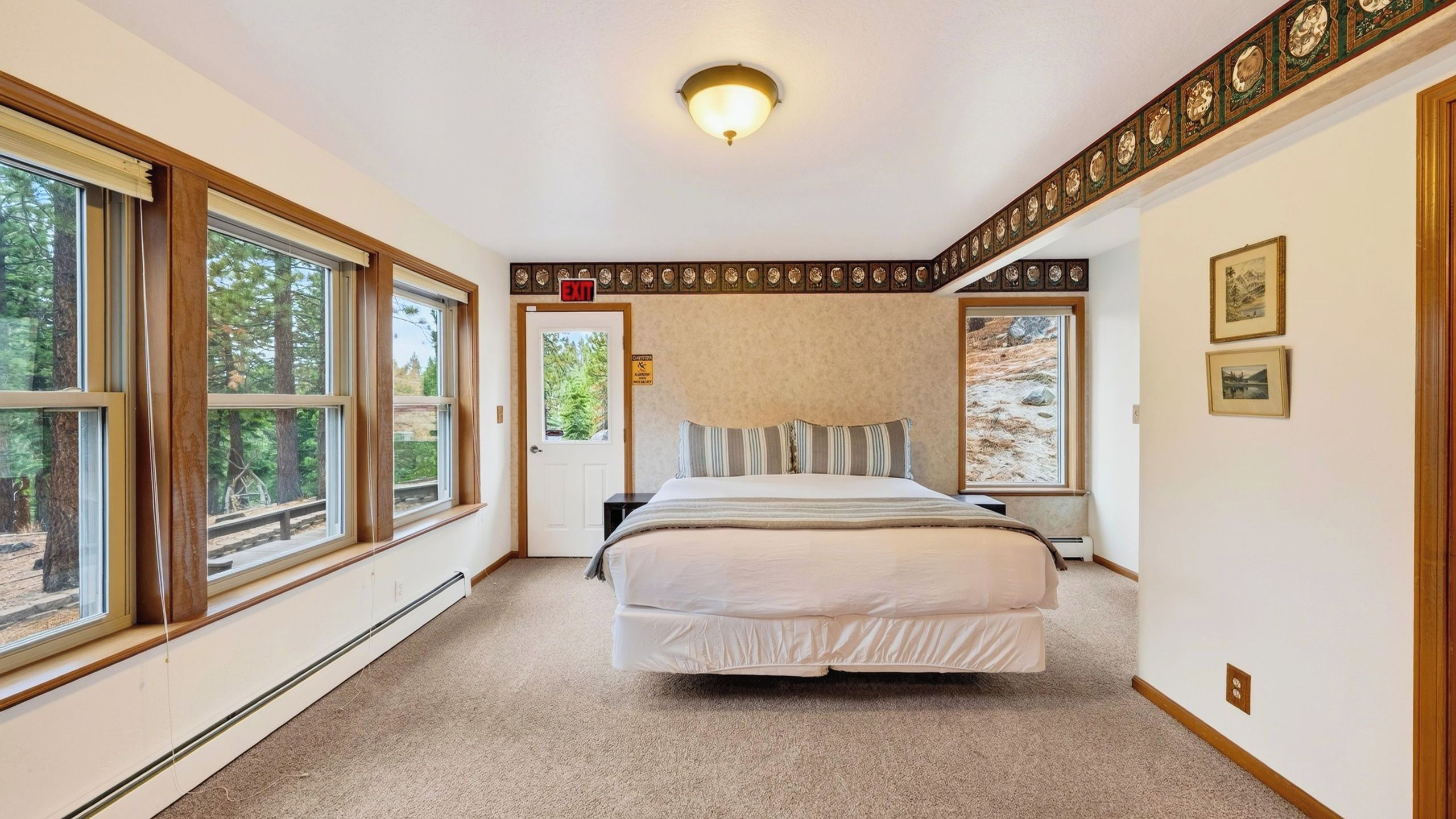 A bedroom with a bed, a window, and a door.